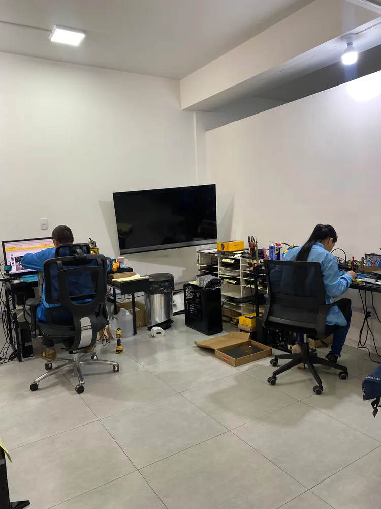 Laboratório com duas estações de trabalho e a equipe em atendimento