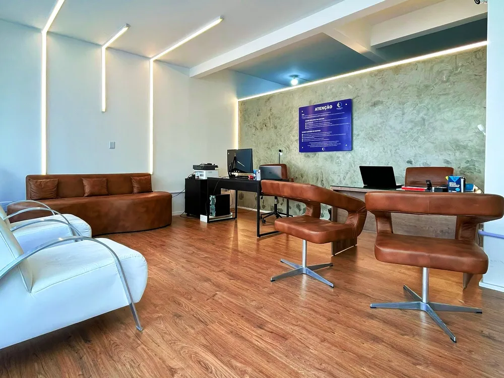 Sala de espera com sofá, poltronas e iluminação em LED